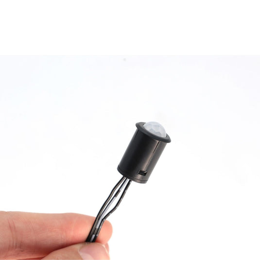 Hand holding the PIR sensor by its cable