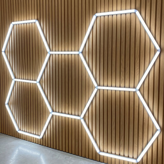 Five hexagon LED kit on a ceiling above acoustic panels