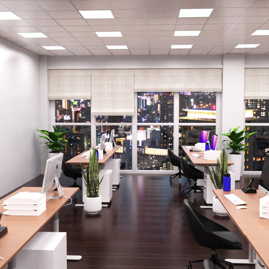 Office lit by cool white LED panels with a city view