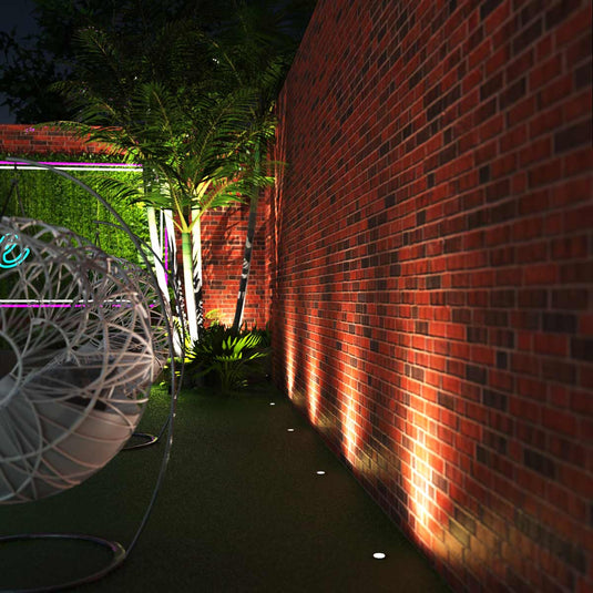 Garden with ground lights along a brick wall