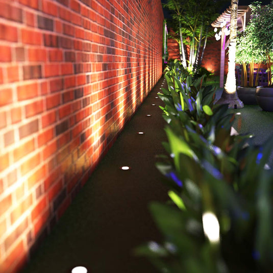 Ground lights lighting a brick garden wall