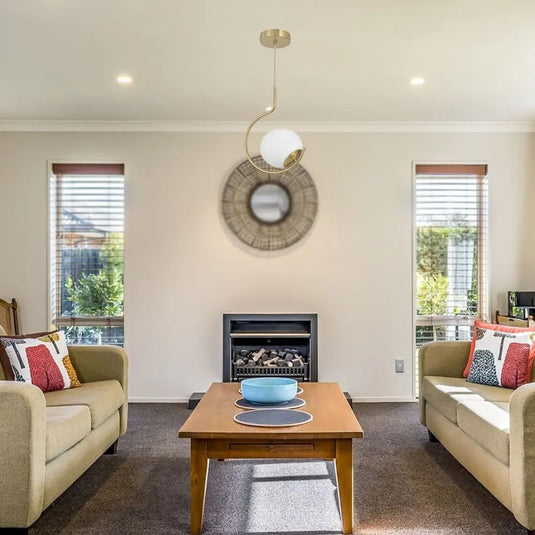 Hook Shaped Pendant Light with a Glass Sphere in a living room setting