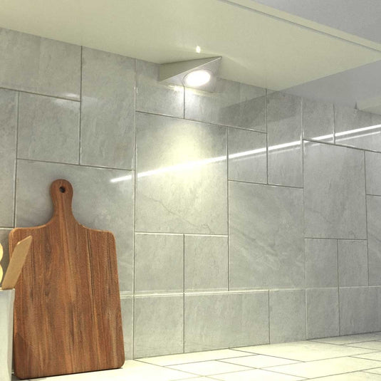 close up of a mounted triangle under cabinet light with warm white light