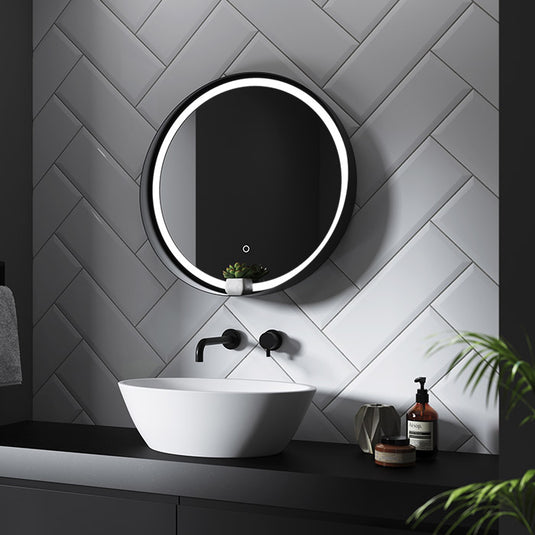 round LED mirror with black trim and decorative shelf
