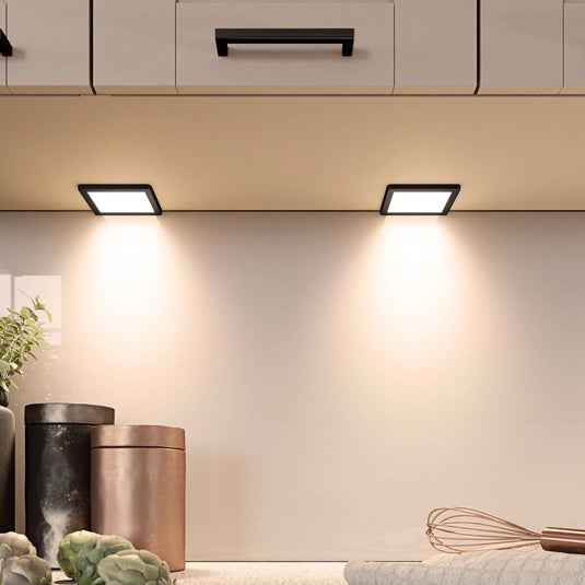 square under cabinet lights with black bezel in warm white light