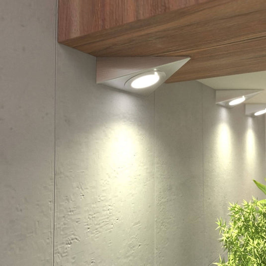close up of mounted triangle under cabinet lights with warm white light