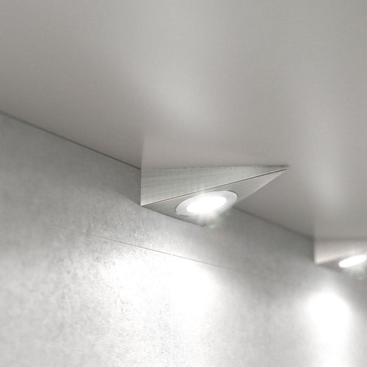 close up of a mounted triangle under cabinet light with natural white light