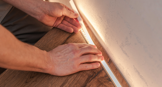 Man installing LED strip lights.