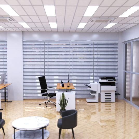 Cool white LED panels lighting an office with desks and copiers