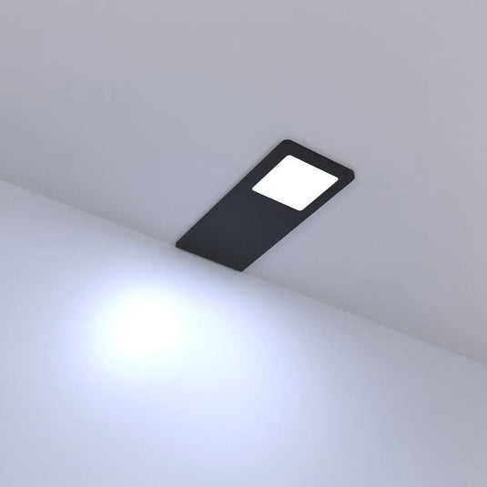 Black Recti Superslim 5w LED Cabinet Light, in cool white light lit, sideways angle