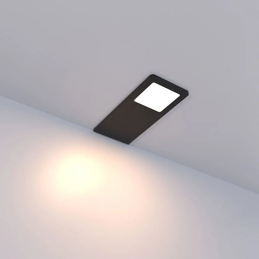 Black Recti Superslim 5w LED Cabinet Light, in warm white light lit, sideways angle