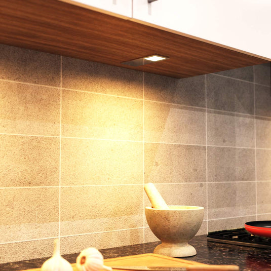 Warm white glow on a worktop from a cabinet light