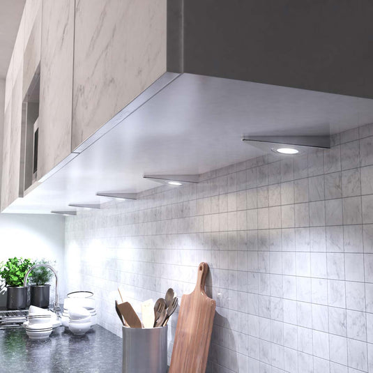 Kitchen lit by cool white triangle cabinet lights