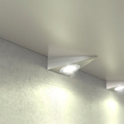 close up of a mounted triangle under cabinet light with warm white light